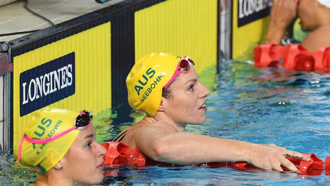 Emily Seebohm of Australia (right) checks the clock after winning a silver medal in the Women's 100 Backstroke Final on day three of swimming competition at the XXI Commonwealth Games at Gold Coast Aquatic Centre on the Gold Coast, Australia, Saturday, April 7, 2018. (AAP Image/Dave Hunt) NO ARCHIVING, EDITORIAL USE ONLY