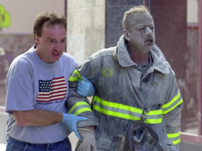 A firefighter covered with ash is escorted from the World Trade Centre. Picture: Thomas Monaster/NY Daily News