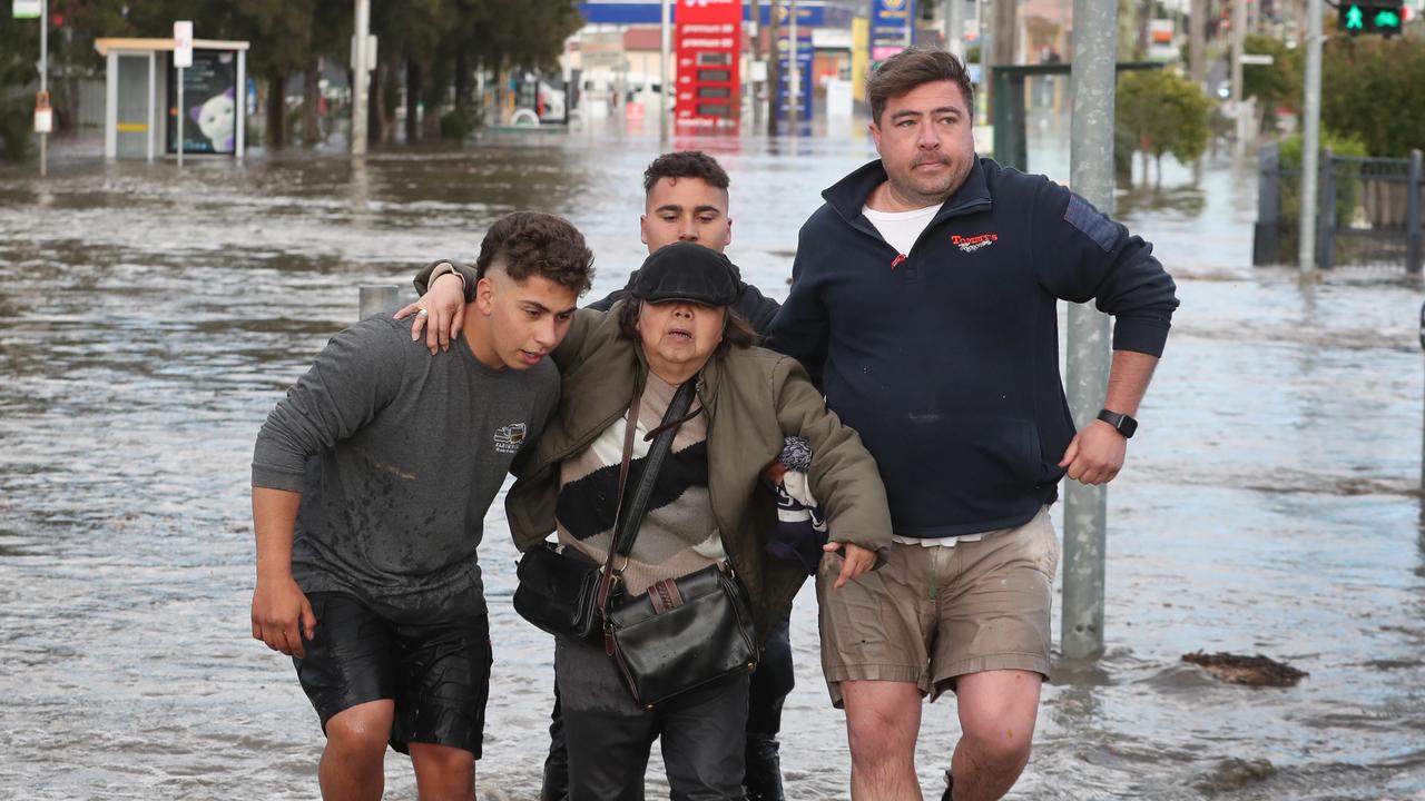 A man is helped by locals as he leaves his house on Raleigh Rd in Maribyrnong. Picture: NCA NewsWire / David Crosling