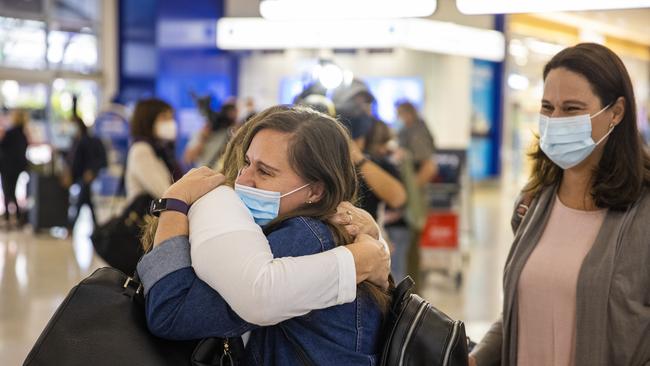 SYDNEY, AUSTRALIA - APRIL 19: A New Zealand traveler is embraced at Sydney International Airport on April 19, 2021 in Sydney, Australia. The trans-Tasman travel bubble between New Zealand and Australia begins on Monday, with people able to travel between the two countries without needing to quarantine. (Photo by Jenny Evans/Getty Images)