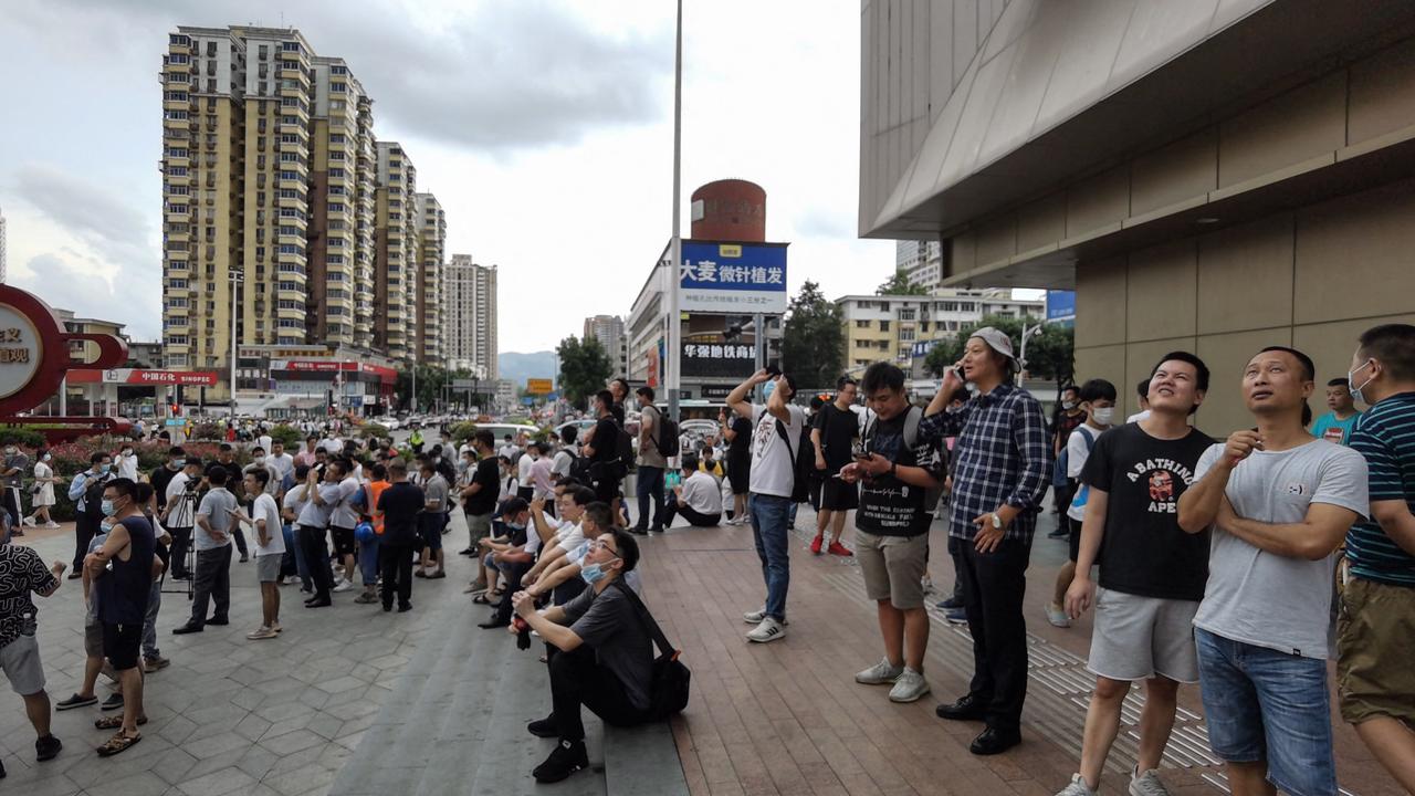 People stand near the 300-metre high SEG Plaza after it began to shake. Picture: STR/AFP/China Out