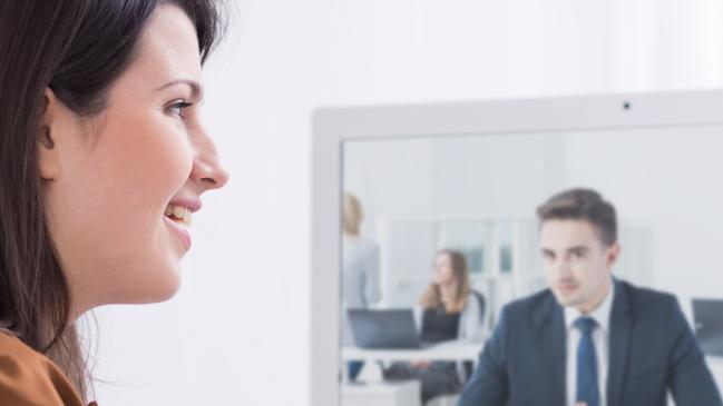 CAREERS: Young woman in front of computer talking with businessman.