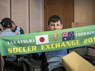 Toowoomba team member Sam Fraser displays a cloth banner given to members to mark the 2016 Soccer Exchange. Picture: Kevin Farmer