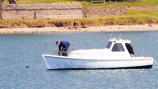 The fishermen prepare to rescue the wallaby. Picture: Bruce Colyer Facebook