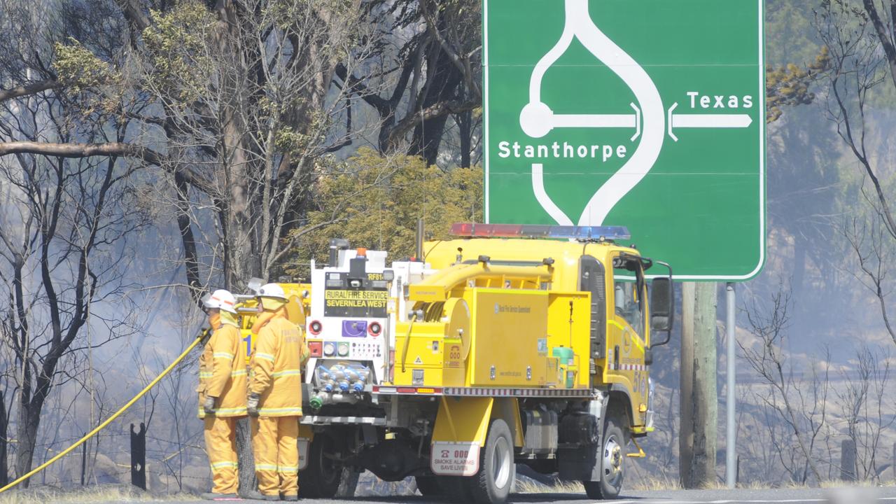 Rural firefighters dousing grass fires at the northern end of Stanthorpe on the New England Highway.