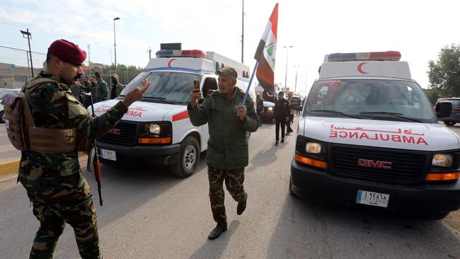 Iraqi military personnel gathered on Sunday near ambulances carrying the coffins of people who were killed in recent US airstrikes in western Iraq. Picture: Shutterstock/WSJ