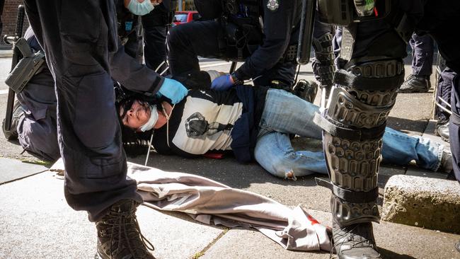 A woman is detained by Victoria Police during an anti-lockdown protest in Melbourne in 2020.