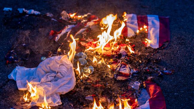 A burnt US flag is seen on the ground amid clashes with law enforcement in the streets surrounding the federal building during a protest following federal immigration operations in Los Angeles, California.
