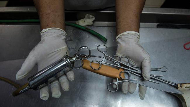 Embalmer Alejandro Ormeneta displaying embalming instruments before operating on a body inside the morgue of Veronica Memorial Chapel in Manila. Picture: AFP / Noel Celis.