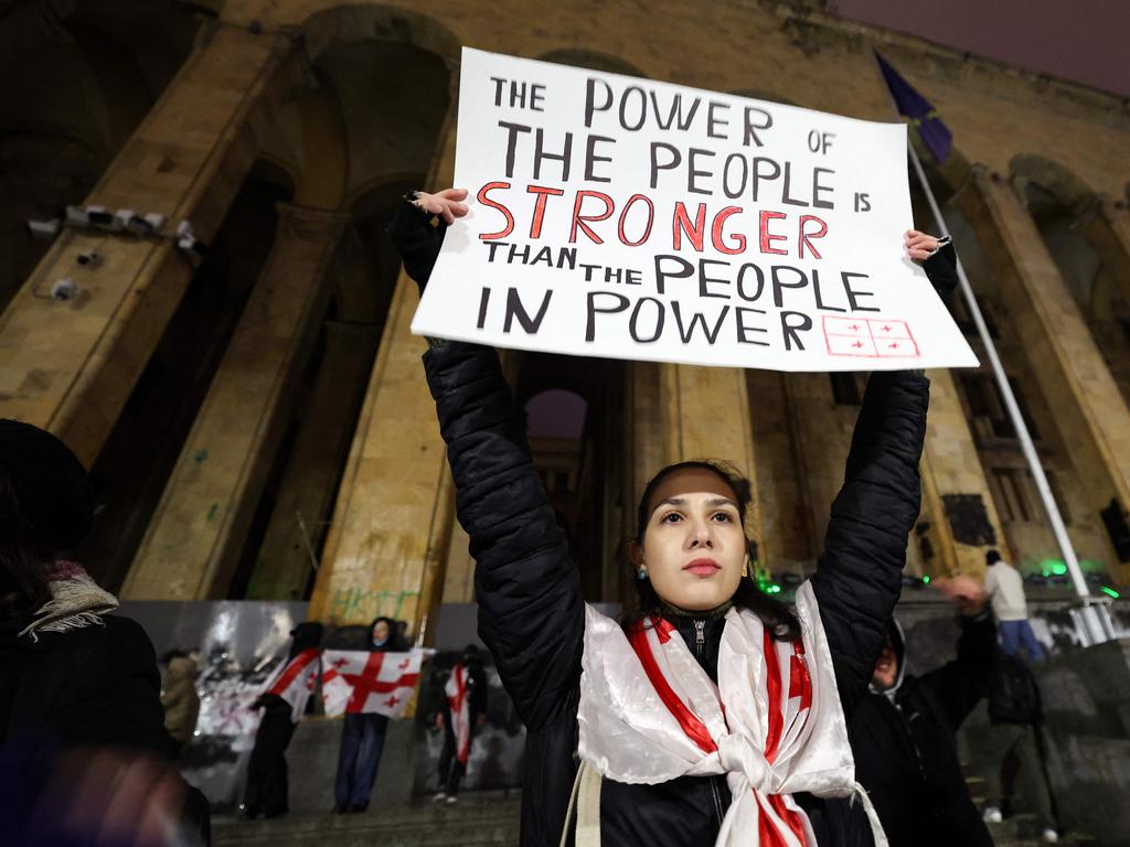 A demonstrator holds up a sign that says ‘The power of the people is stronger than the people in power’. Picture: Giorgi ARJEVANIDZE / AFP