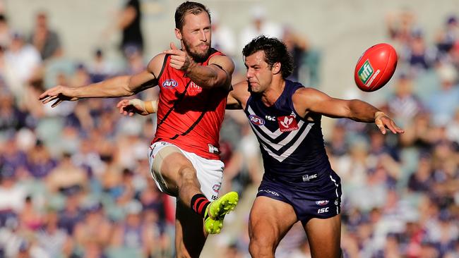 James Kelly gets his kick away under pressure from Brady Grey.