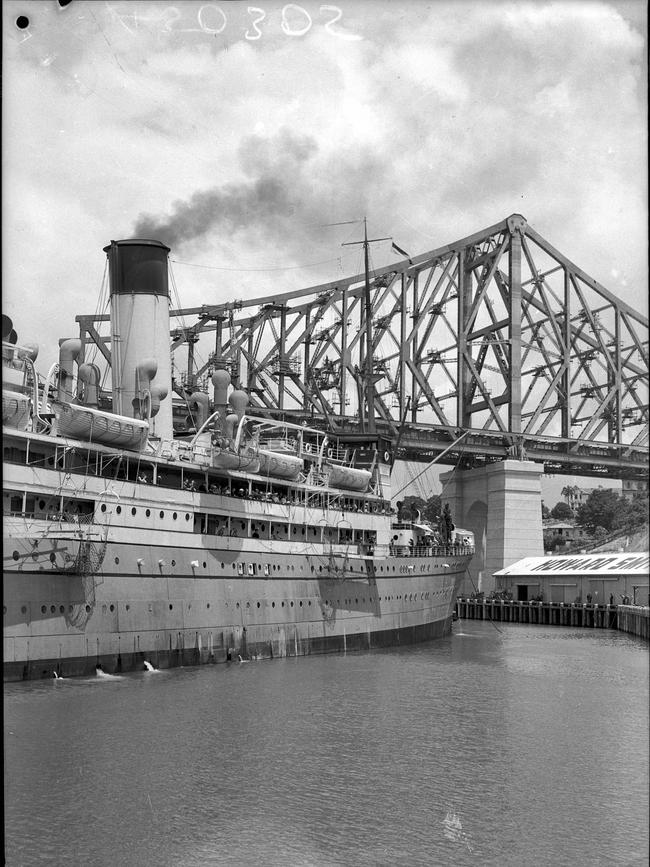A ship is towed by tug up the Brisbane River during the Story Bridge’s construction in 1939