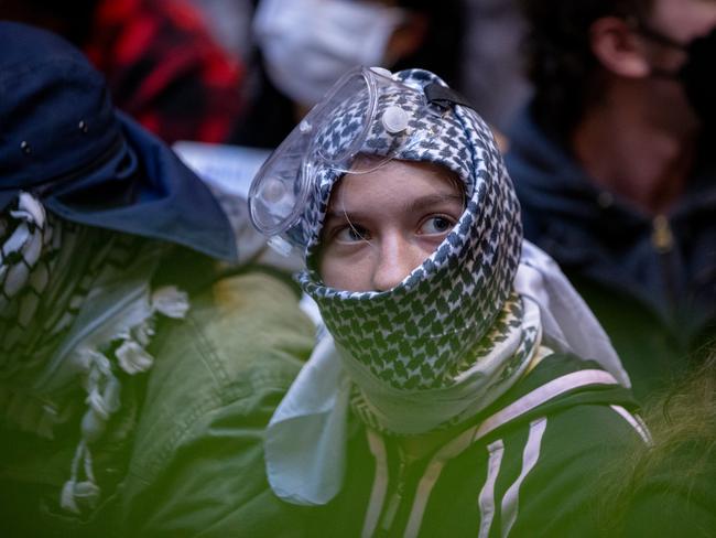 A protester hides their face. Picture: Jason Edwards