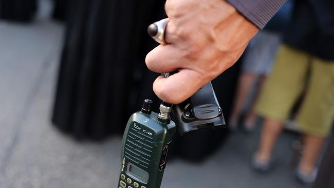 A man holds a walkie talkie device after he removed the battery during the funeral of persons killed when hundreds of paging devices exploded in a deadly wave across Lebanon on Tuesday. (Photo by ANWAR AMRO / AFP)