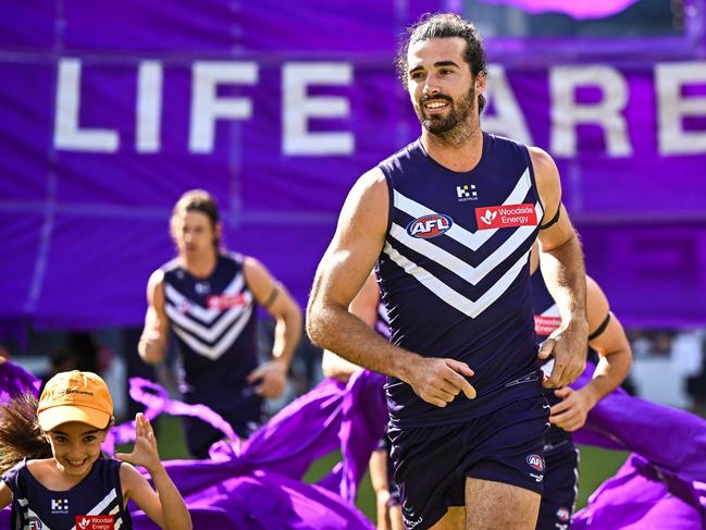 PERTH, AUSTRALIA - MARCH 17: Alex Pearce of the Dockers leads the team through the banner during the 2024 AFL Round 01 match between the Fremantle Dockers and the Brisbane Lions at Optus Stadium on March 17, 2024 in Perth, Australia. (Photo by Daniel Carson/AFL Photos via Getty Images)