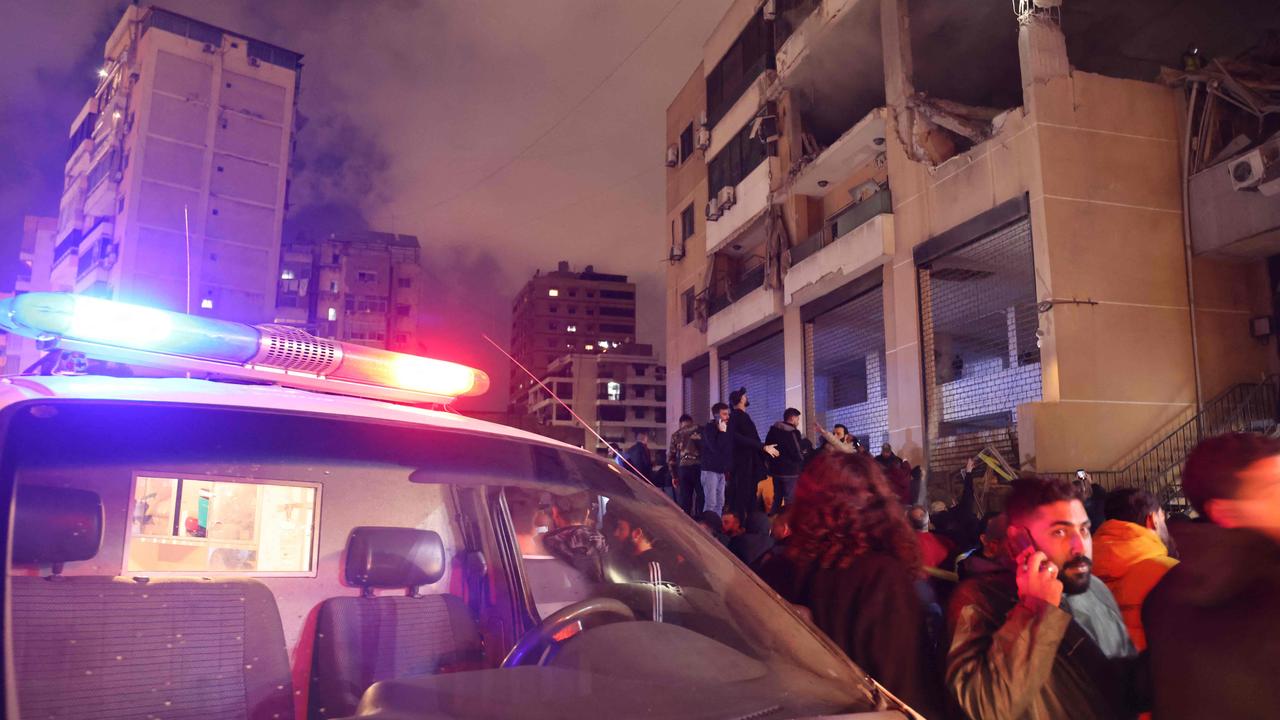 People gather at the site of a strike, reported by Lebanese media to be an Israeli strike targeting a Hamas office, in the southern suburb of Beirut on January 2, 2024. (Photo by Anwar AMRO / AFP)