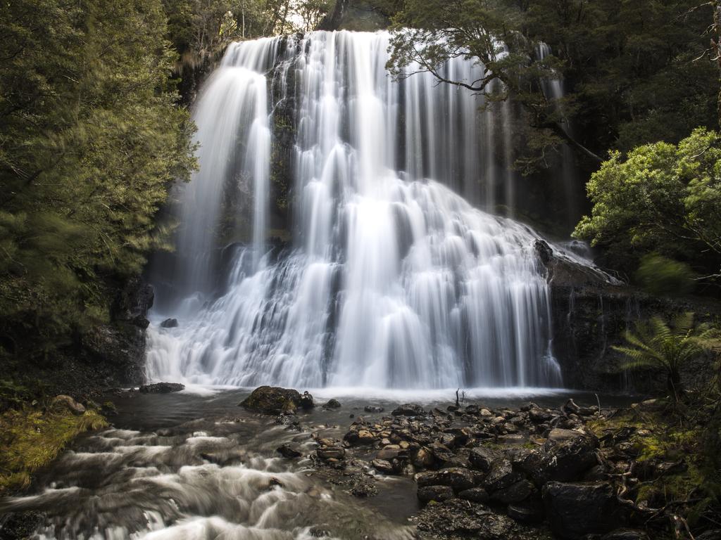 A beautiful waterfall in Moina, Tasmania that allows viewers a view beside and slightly behind the falls.