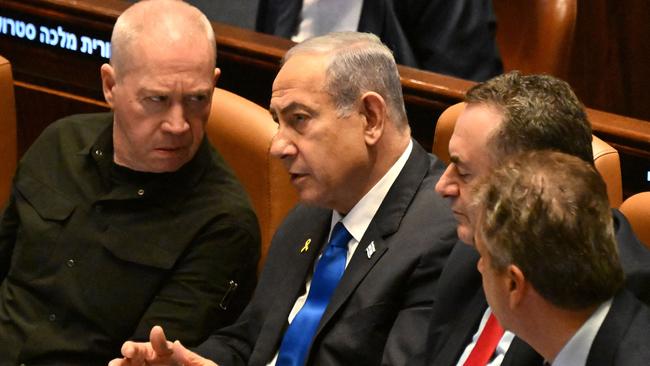 Benjamin Netanyahu (C) speaks to Defence Minister Yoav Gallant (L) at the opening of the 25th parliament session in Jerusalem. Picture: AFP.