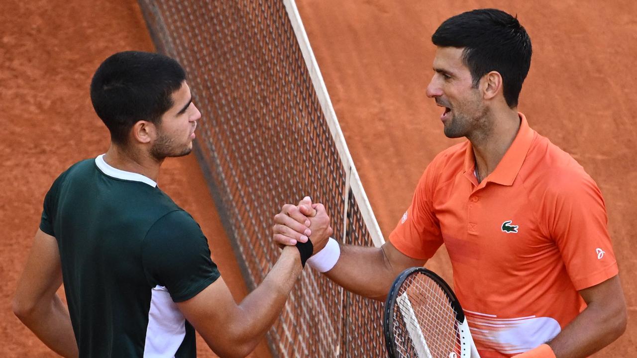 Spain's Carlos Alcaraz (L) and Serbia's Novak Djokovic shake hands at the end of their 2022 ATP Tour Madrid Open tennis tournament men's singles semi-final match at the Caja Magica in Madrid on May 7, 2022. (Photo by GABRIEL BOUYS / AFP)