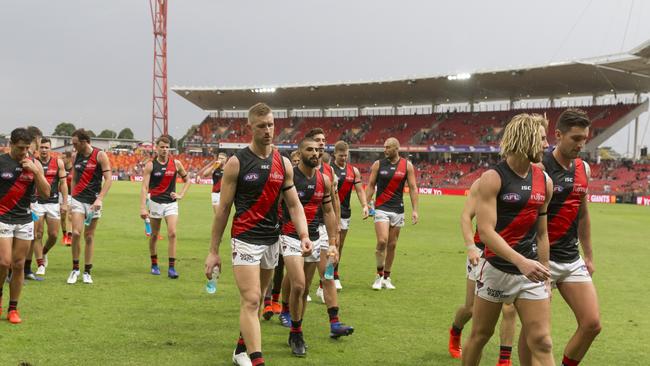 Dejected Essendon players trudge off Giants Stadium after their heavy Round 1 defeat. 