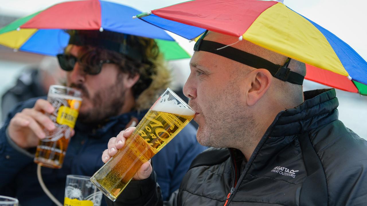 Drinkers came prepare for the inclement weather. (Photo by Finnbarr Webster/Getty Images)