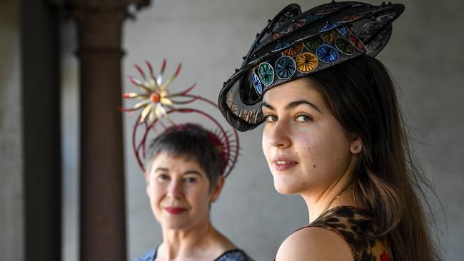 The Melbourne International Millinery Competition organiser Catherine Ellen wearing a piece made out of Pepsi cans and onion bags by Sandy Hunter, with Sara Court wearing a piece made of coffee pods by Sandy Aslett. Picture: Penny Stephens