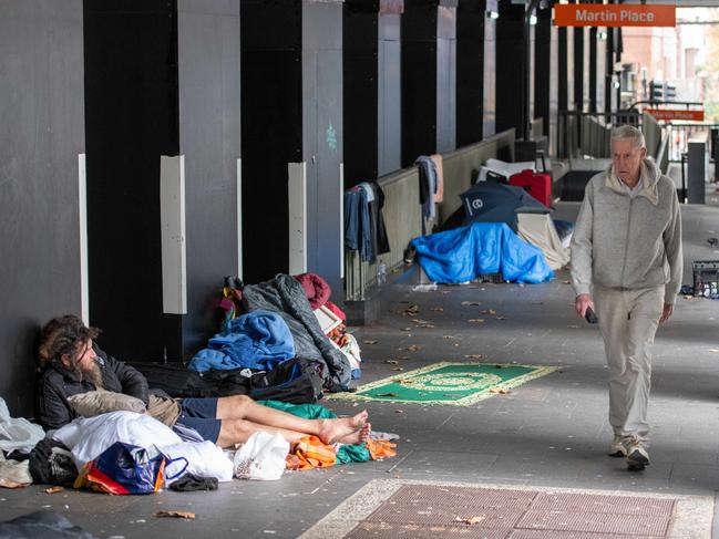 A man walks past the homeless bedded down outside the RBA building. Picture: Thomas