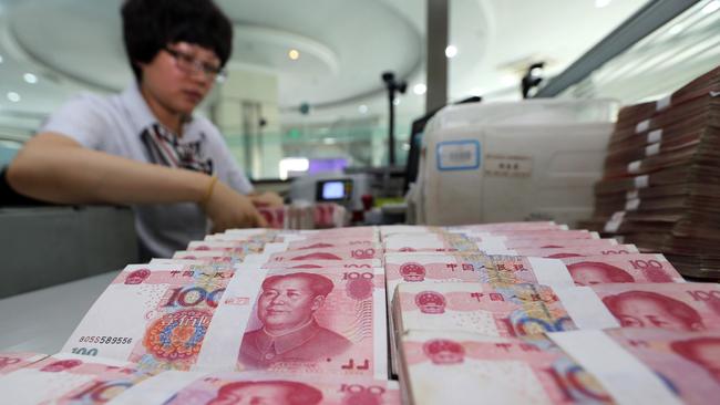 A teller counts yuan banknotes in a bank in Lianyungang, east China's Jiangsu province. AFP PHOTO