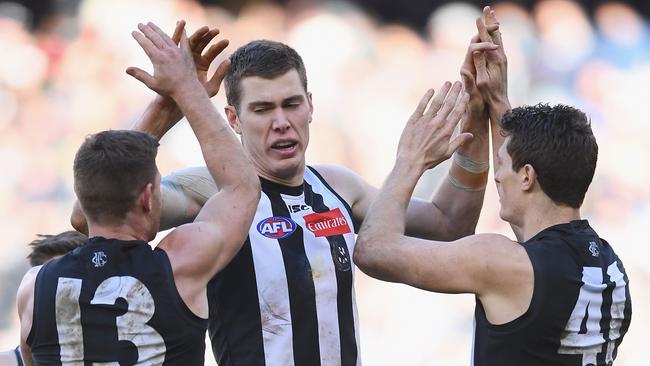 Mason Cox of the Magpies is congratulated by teammates after kicking a goal. Picture: Quinn Rooney/Getty Images