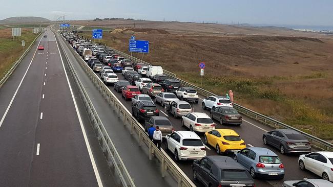 Vehicles wait to cross the Kerch Bridge overnight (AEDT). Picture: AFP