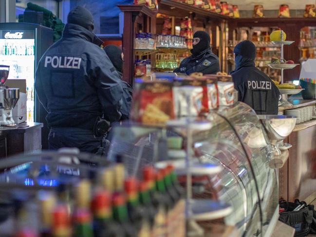 Policemen raid a cafe in Germany, as part of a mafia crackdown. Picture: AFP