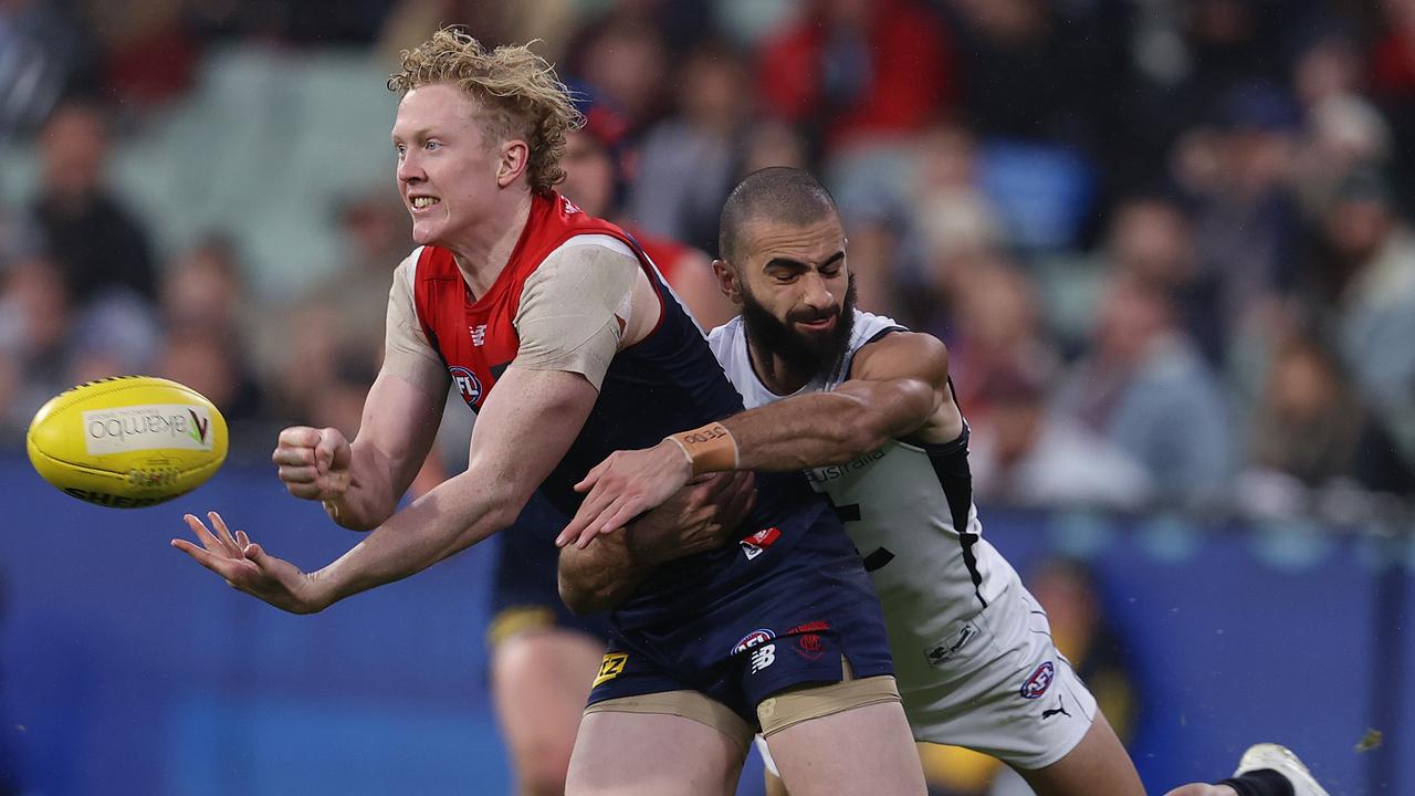 AFL Round 9. 16/05/2021 . Melbourne vs Carlton at the MCG, Melbourne. Clayton Oliver of the Demons clears. Y hand as he is tackled by Adam Saad of the Blues . Pic: Michael Klein