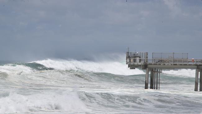 Tourists and locals watch on as giant surf pounds Gold Coasts northern beaches. Picture Glenn Hampson
