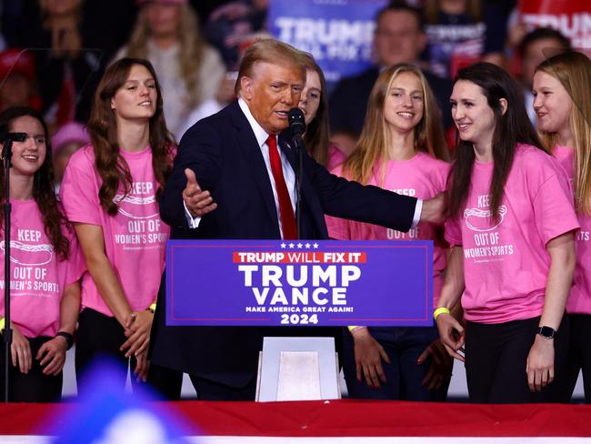 Republican presidential nominee and former U.S. President Donald Trump gestures next to members of Roanoke College swimming team, at a campaign rally at Salem Civic Center, in Salem, Virginia, U.S. November 2, 2024. REUTERS/Hannah McKay