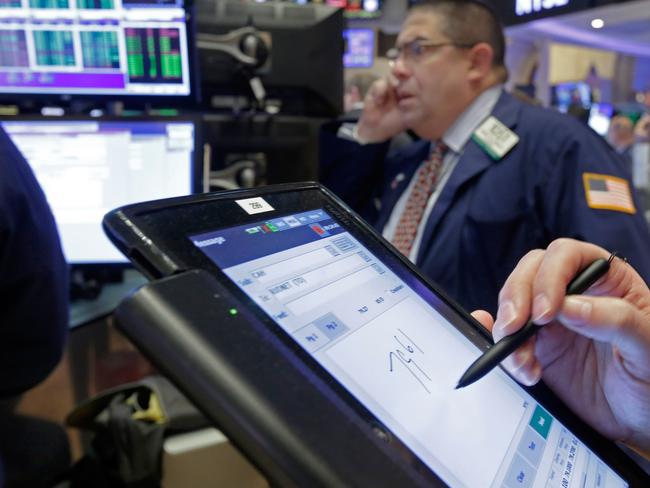 A trader, foreground, uses his handheld device as he works on the floor of the New York Stock Exchange, Tuesday, Jan. 12, 2016. U.S. stocks are opening higher, led by gains in big technology companies, which have had a rough start to the year. (AP Photo/Richard Drew)