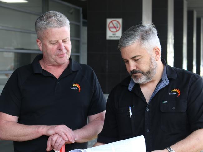 TasTAFE automotive teacher Tristan Sabol reads independent air quality monitoring report to a colleague outside TAFE following carbon monoxide poisoning incident. Picture: Elise Kaine