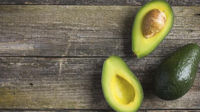 food background with fresh organic avocado on old wooden table, top view, copy space