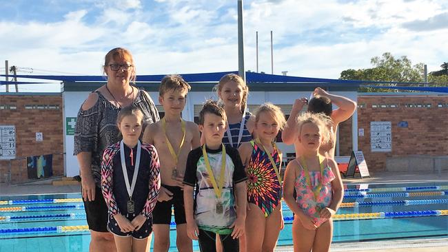 Ann-Marie Williamson, who was the Collinsville Swimming Club president, with junior mixed relay competitors Lex Ansen, Lily West, Clay Colls (back), Lexi Whelan, Kyan Tiechmann, Emily Ansen, Ruby Pyke (front) in 2017.