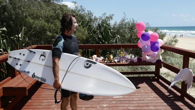 A surfers stands at tribute to the baby that was found dead on the beach in Surfers Paradise near Staghorn Ave. Photo: Tertius Pickard