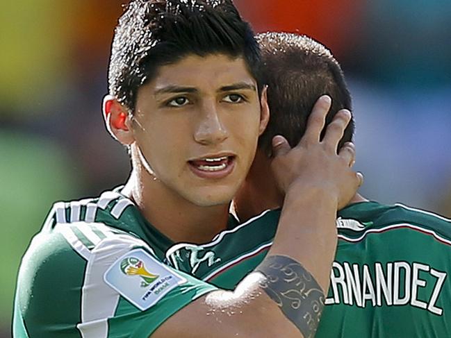 FILE - In a June 29, 2014 file photo, Mexico's Alan Pulido consoles teammate Javier Hernandez (14) after the Netherlands defeated Mexico 2-1 during the World Cup round of 16 soccer match between the Netherlands and Mexico at the Arena Castelao in Fortaleza, Brazil. A state official says that Mexican soccer star Alan Pulido has been kidnapped in the northern border state of Tamaulipas. The official says the 25-year-old player was kidnapped near his hometown of Ciudad Victoria on Sunday after leaving a party. (AP Photo/Eduardo Verdugo, File)