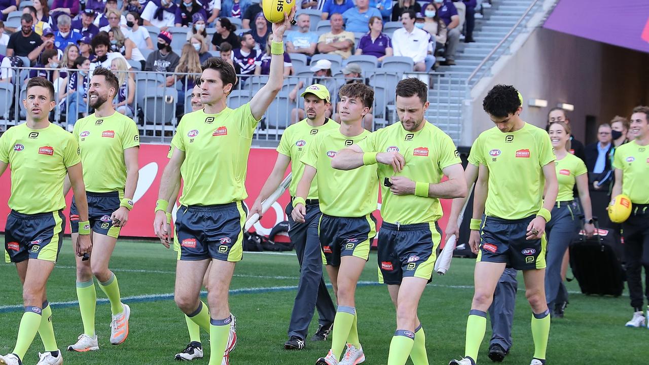 Umpire Matt Stevic walks onto field holding ball aloft. The AFL Umpires’ Association has been excluded from the AFL’s gender action plan.