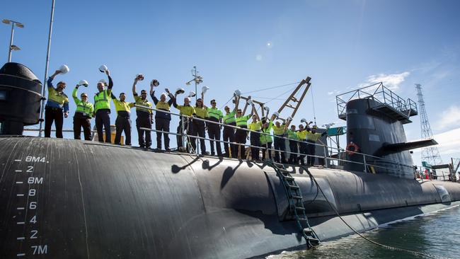 TWELVE MORE: ASC workers celebrate on the Adelaide-built Collins Class sub HMAS Farncomb, docked at the Osborne shipyard.