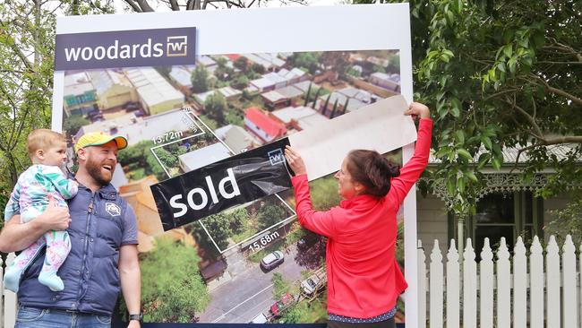 Joe and Clare put up the sold sticker. Picture: Hamish Blair
