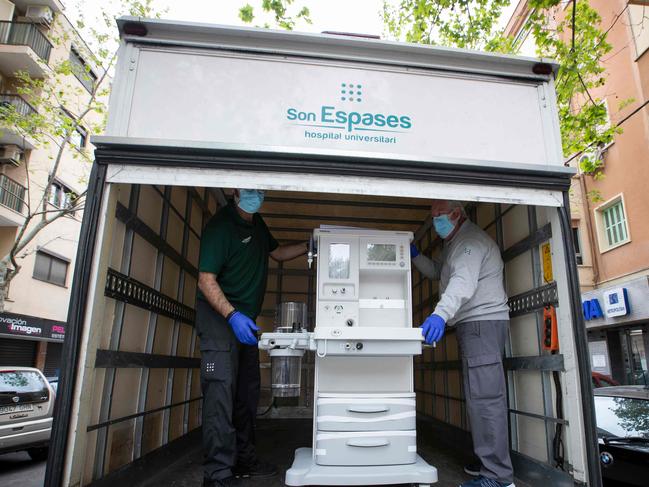 Hospital workers transfer a respirator from a veterinary clinic to the Son Espases Hospital in Palma de Mallorca. Picture: AFP.