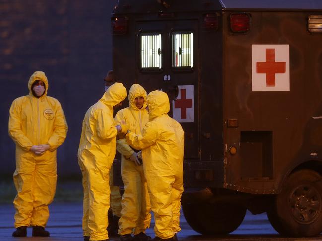 Soldiers wear protective suits before the arrival of Brazilians repatriated from Wuhan. Picture: AP