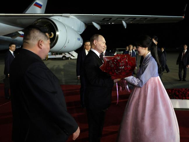 Kim Jong-un looks on as Russian President Vladimir Putin receives flowers during a welcoming ceremony. Picture: AFP