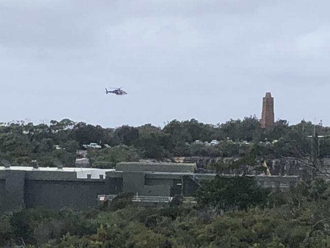 A NSW Police helicopter near the North Head Sewage Treatment Plant on North head during the search for a missing Swedish student who was swept off rocks at Blue Fish Point. Picture: Jim O’Rourke