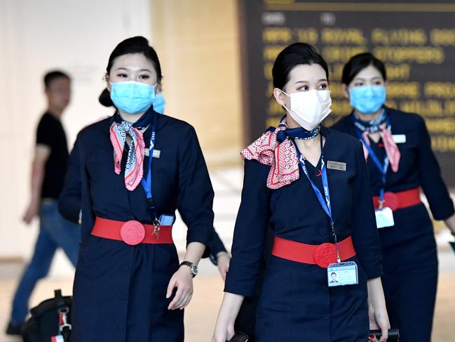 China Eastern Airlines cabin crew are seen wearing protective face masks at Brisbane International Airport in Brisbane, Wednesday, January 29, 2020. Australia has had five confirmed cases of coronavirus, four in New South Wales and one in Victoria since the virus outbreak started in China. (AAP Image/Darren England) NO ARCHIVING