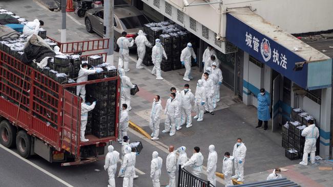 People wear personal protective equipment as they transfer daily food supplies and necessities for local residents during the Covid-19 lockdown in Shanghai, in April 2022. Picture: AFP