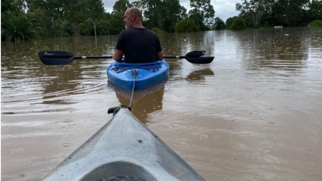 Rachel Baade and her family flee their flooded home in kayaks during Gympie’s floods. Photo: GoFundMe